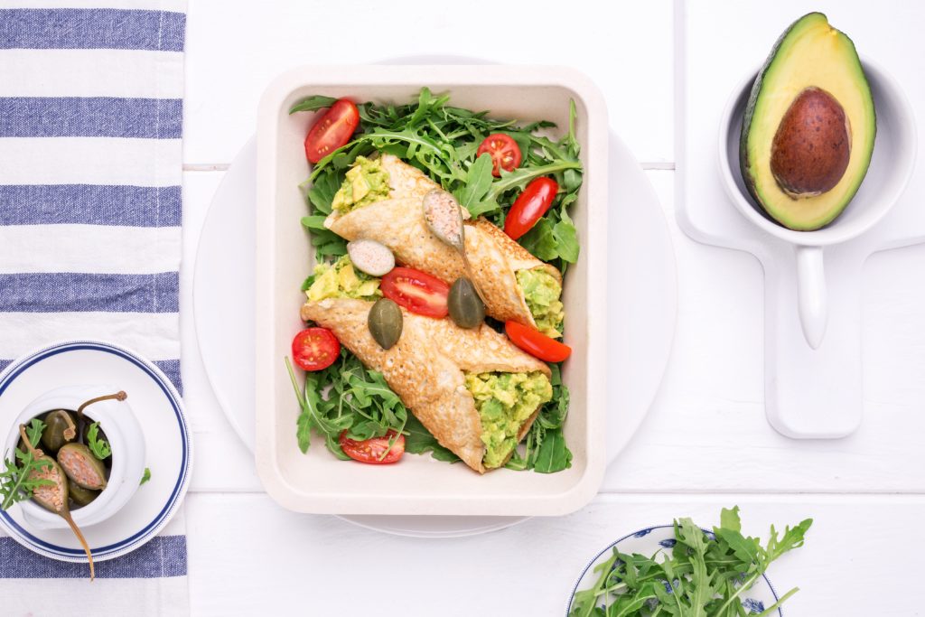 Naleśnik z mąki kokosowej z pastą z awokado i owocami kaparowca, pomidorkami i roszponką